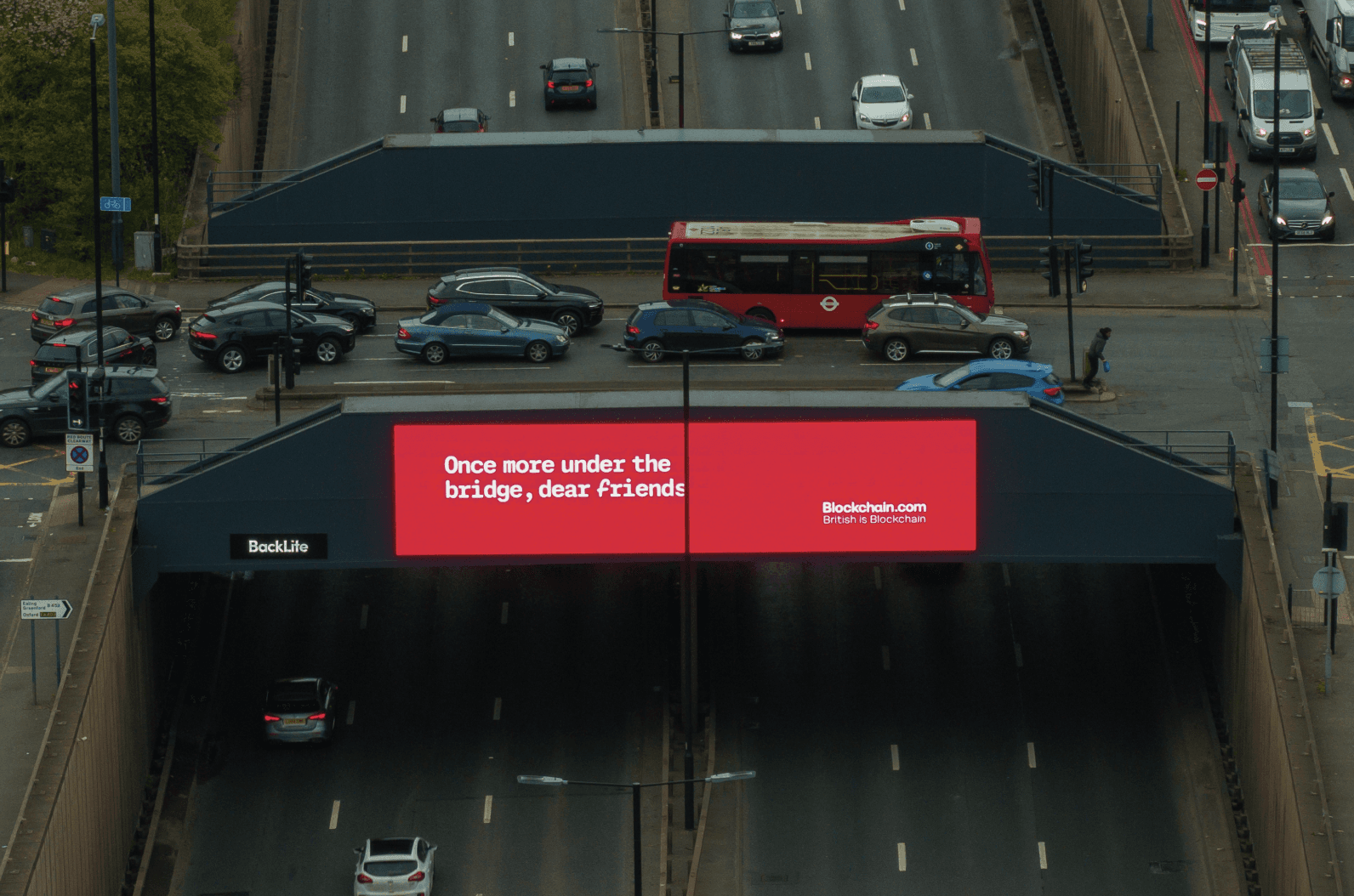 Blockchain.com ‘Once more under the bridge’ billboard seen from above with a red bus