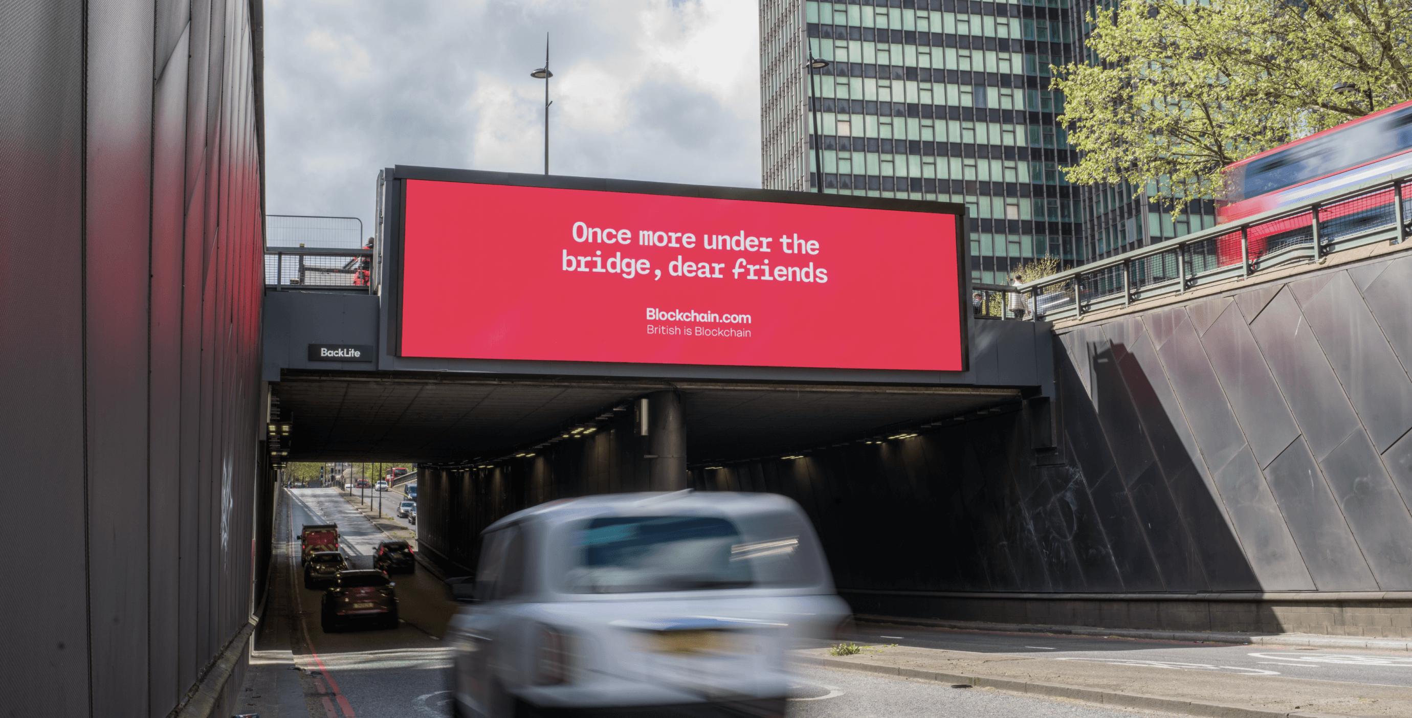 Blockchain.com ‘Once more under the bridge, dear friends’ billboard under a cloudy sky