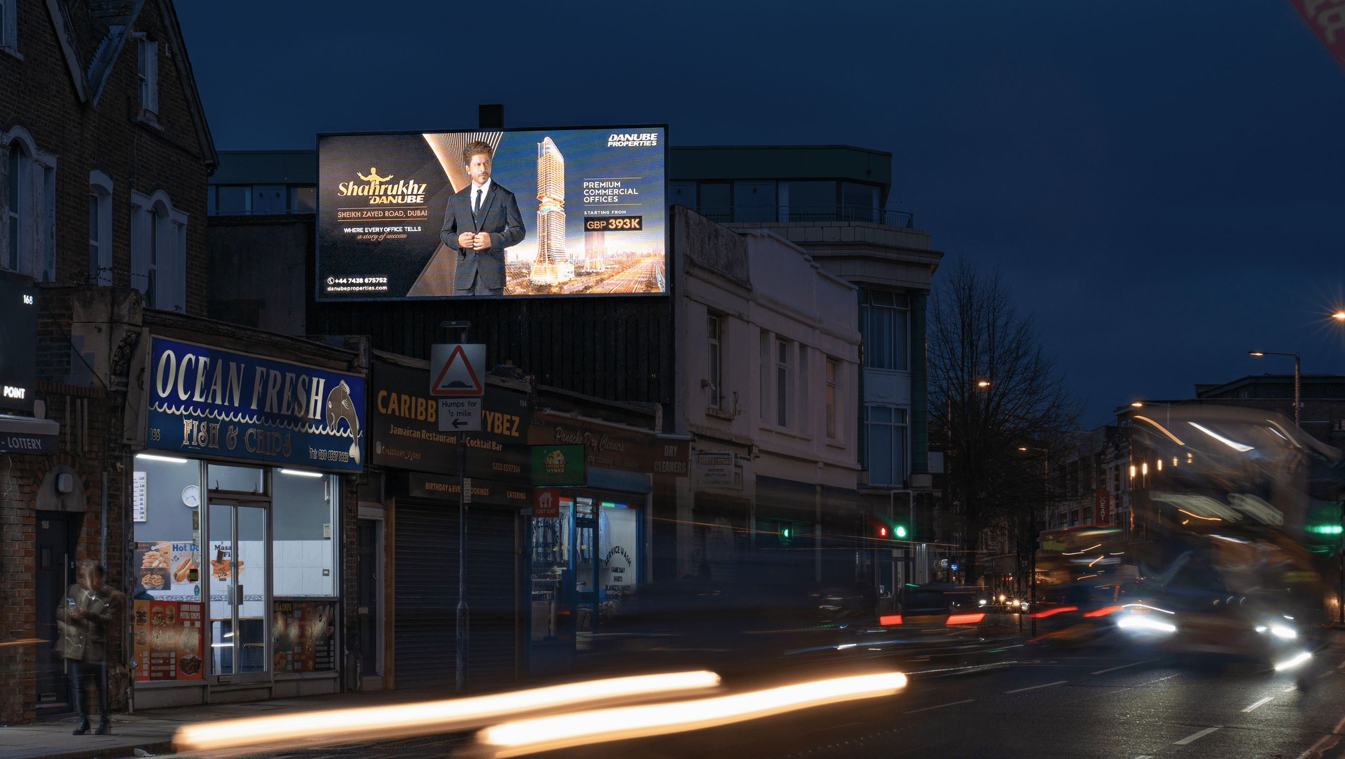 Danube Properties billboard above Ocean Fresh on a London high street at dusk