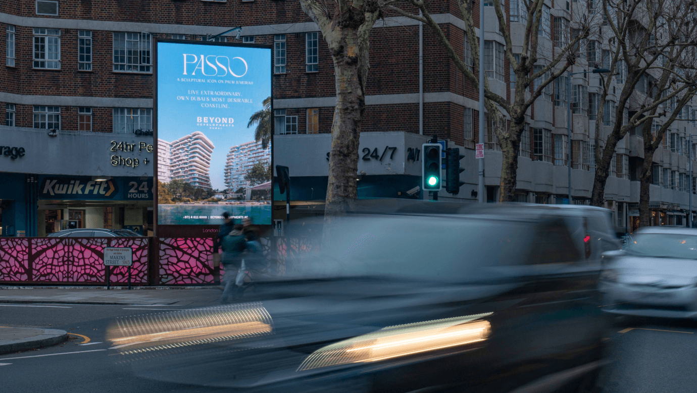 Passo billboard by Beyond above a KwikFit garage on a London street at dusk