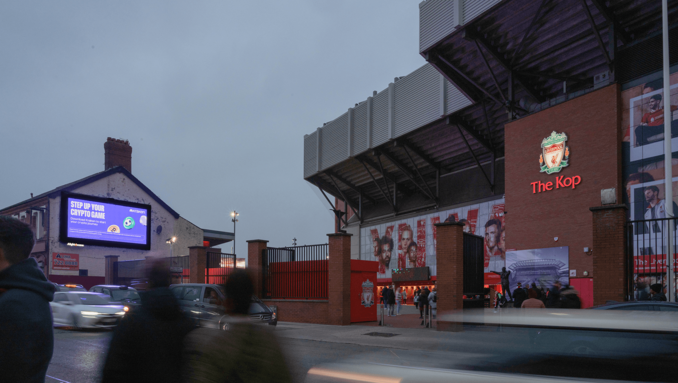 Kraken ‘Step Up Your Crypto Game’ billboard outside Anfield’s Kop stand at dusk