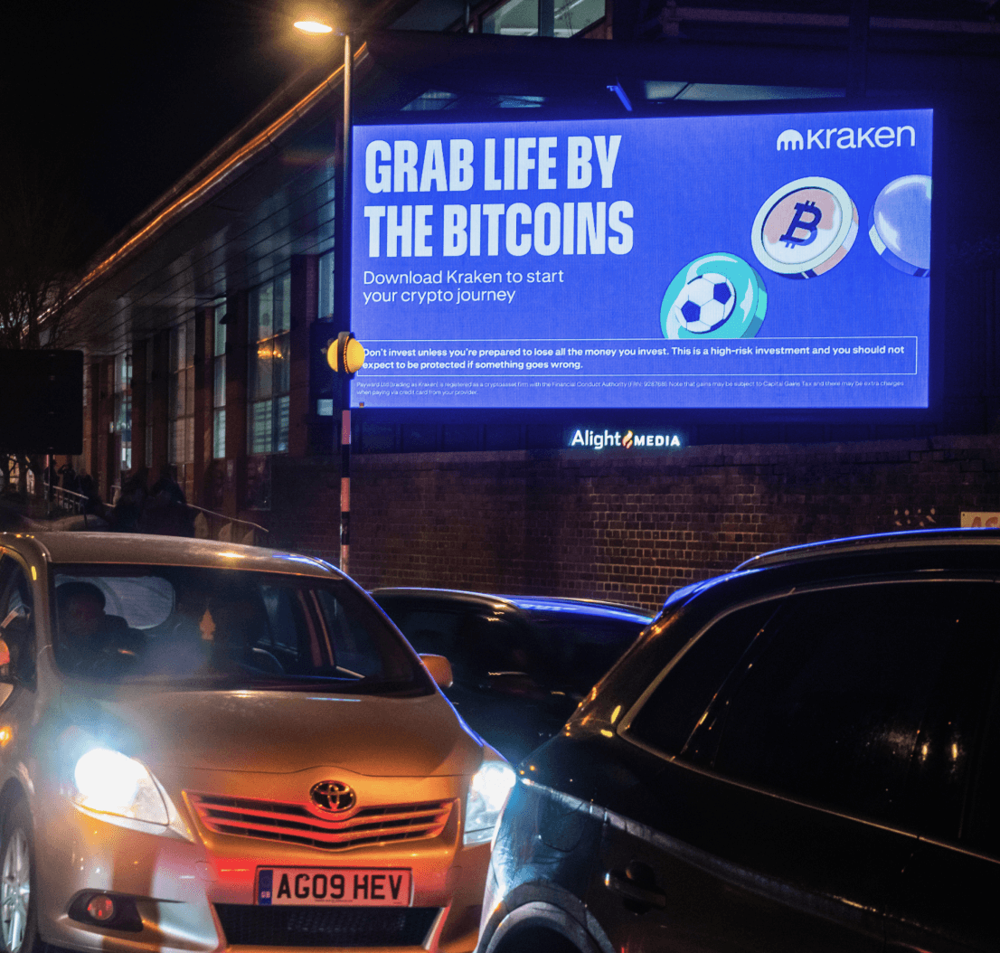 Kraken ‘Grab Life By The Bitcoins’ billboard above nighttime traffic