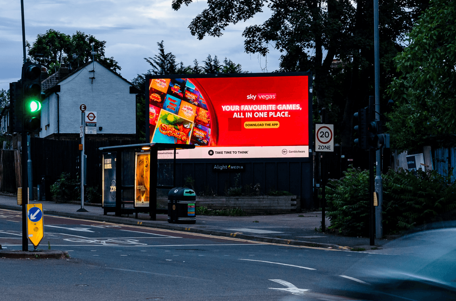 Sky Vegas billboard beside a bus stop on a dusk street
