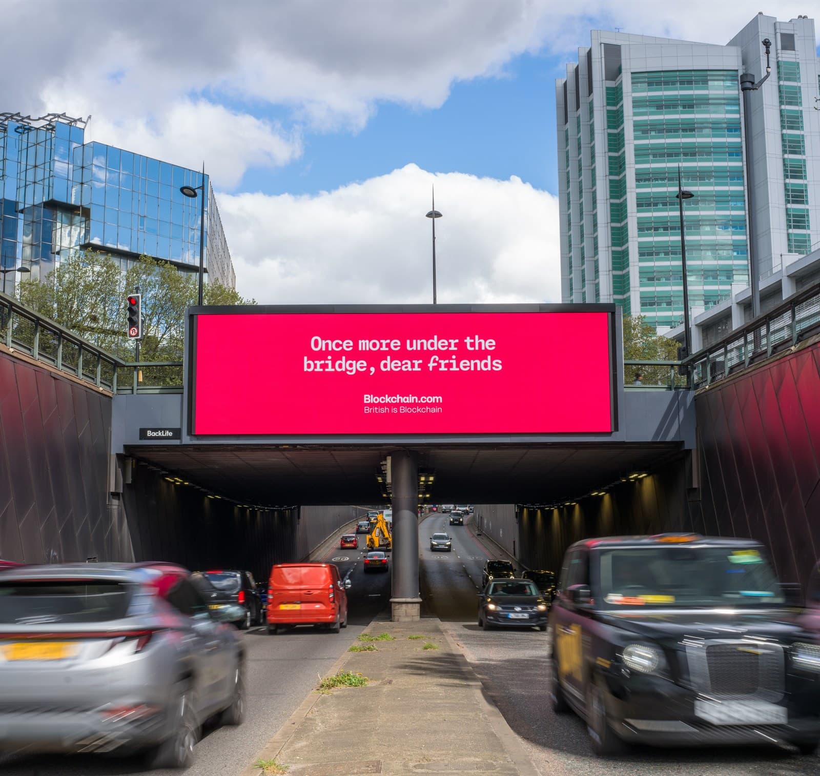 Blockchain.com digital billboard above a London underpass with traffic passing beneath