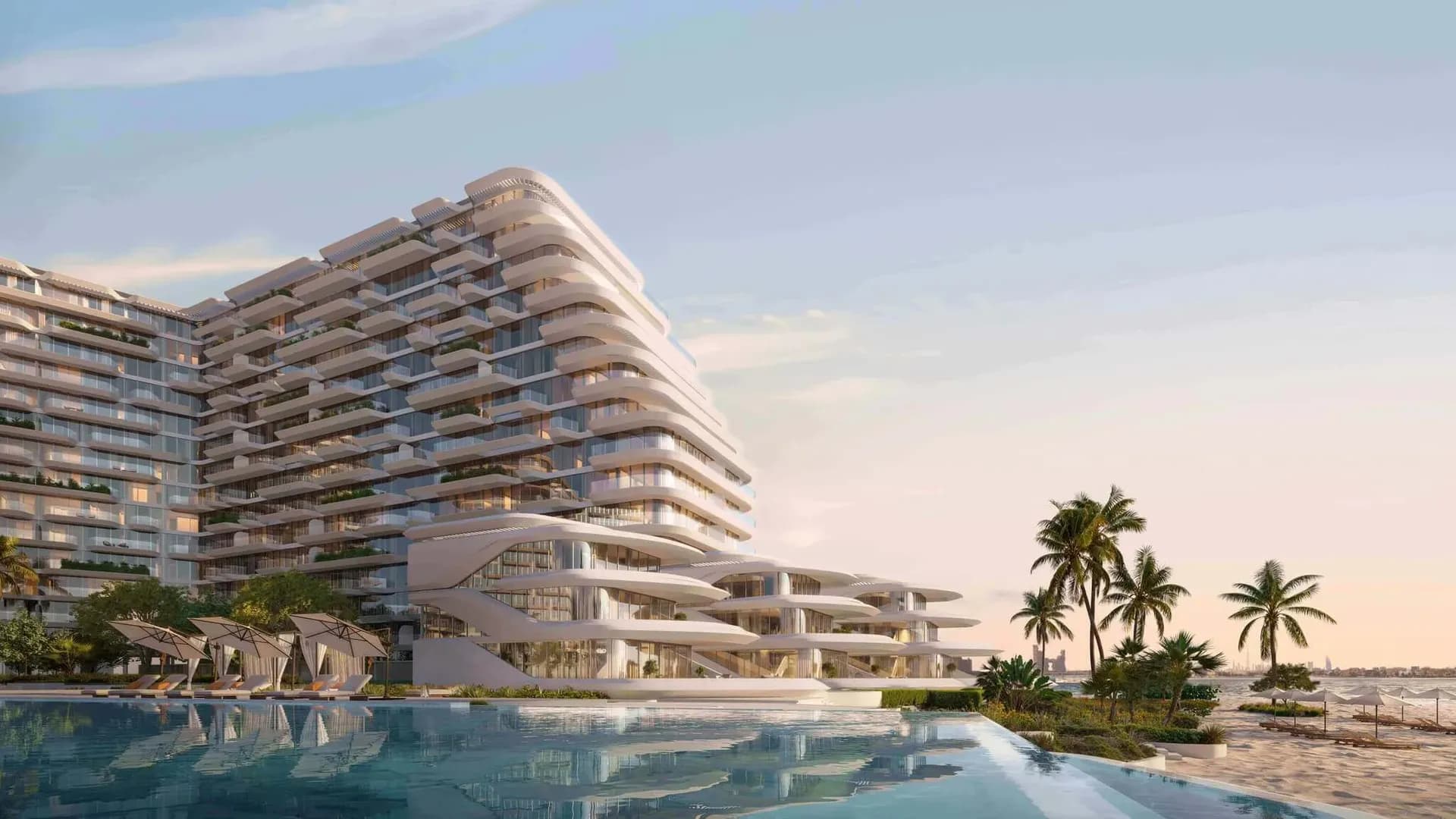 A modern Dubai waterfront residential development beside a palm-lined beach